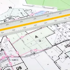 Plan zagospodarowania przestrzennego dla działki "A" z zaznaczonymi granicami i numeracją. Linijka geodezyjna pomaga w analizie.