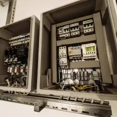Przeniesienie skrzynki elektrycznej zakończone sukcesem. Widać wnętrze z bezpiecznikami, przekaźnikami i okablowaniem.