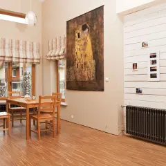 Stylowy salon z obrazem Klimta i grzejnikiem. Zastanawiasz się, jaka moc grzejnika na m2 będzie optymalna?