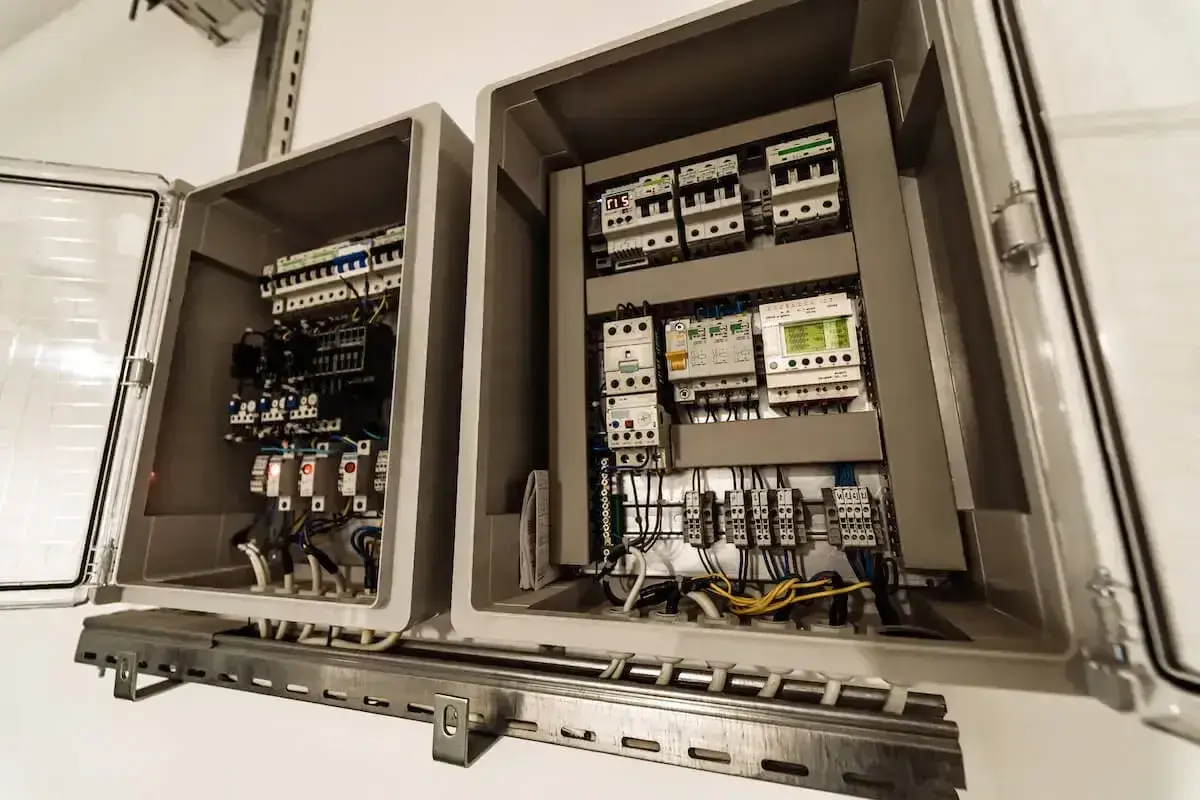 Przeniesienie skrzynki elektrycznej zakończone sukcesem. Widać wnętrze z bezpiecznikami, przekaźnikami i okablowaniem.